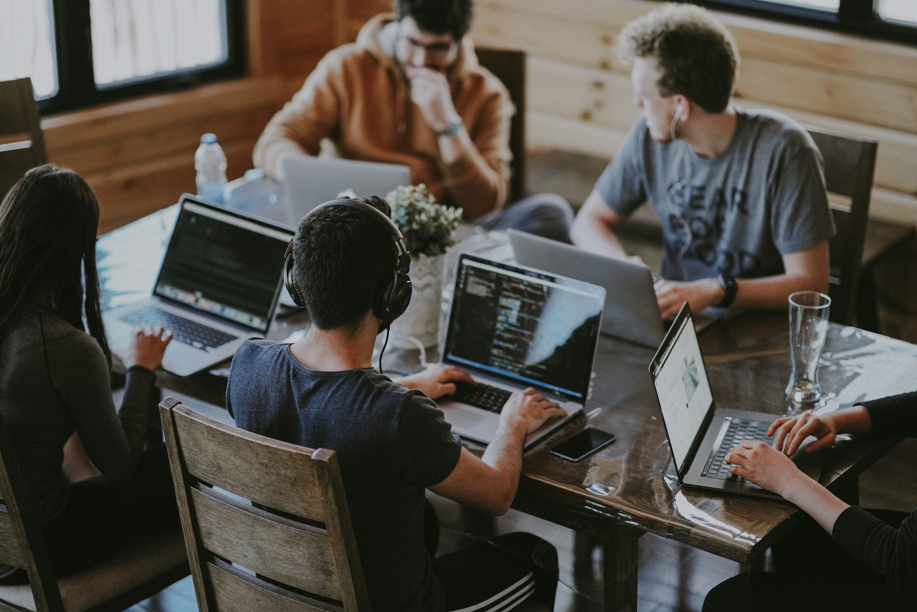 University-age students collaborating on a project around a laptop